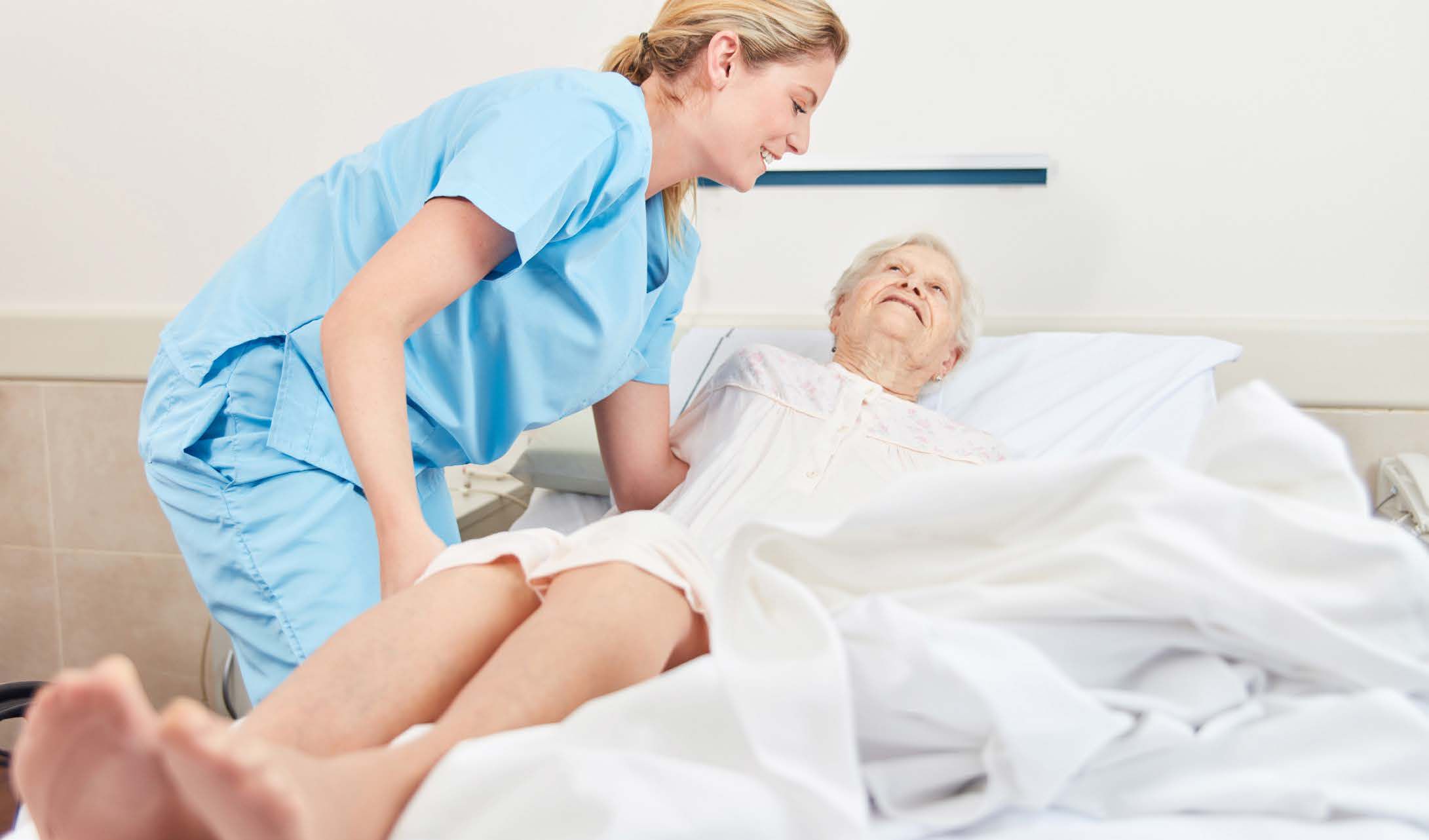 nurse moving patient onto mattress